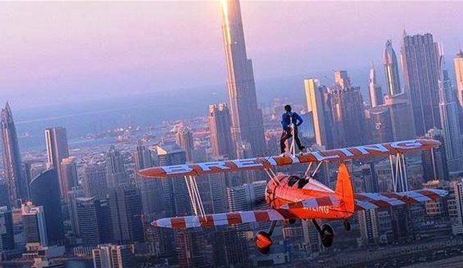 بالفيديو .. ولي عهد دبي واقفا على طائرة شراعية تطير باتجاه برج خليفة 